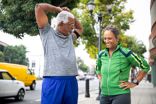 A senior black couple working out in the city.
