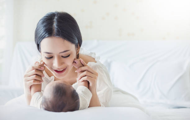 feliz mãe asiática, brincando com o bebê recém-nascido, bebê, falar com a mãe. estilo de vida dia das mães ' s conceito de berçário - asian ethnicity baby mother family - fotografias e filmes do acervo