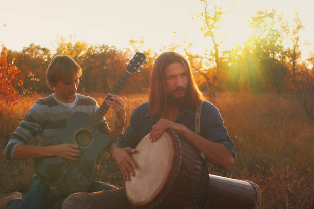 dwóch mężczyzn grających na gitarze i perkusji djembe - folk song zdjęcia i obrazy z banku zdjęć