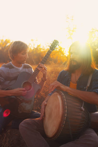istock Two men playing the guitar and djembe drum 1058135260