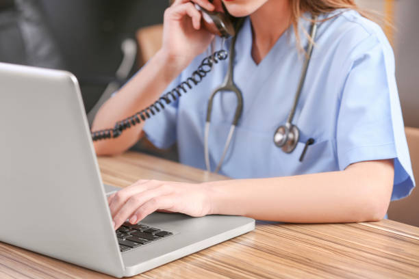 kvinnliga läkare använder en bärbar dator - nurse on phone serious bildbanksfoton och bilder