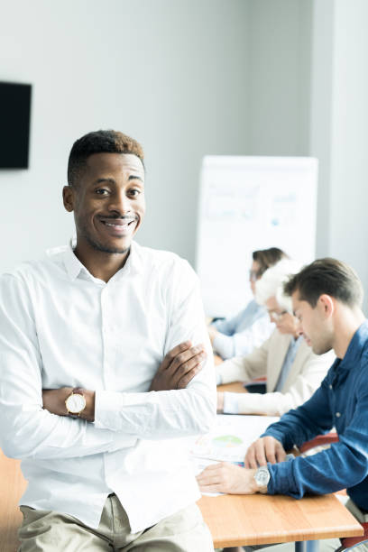istock Smiling African business trainer teaching students at course 1058163504