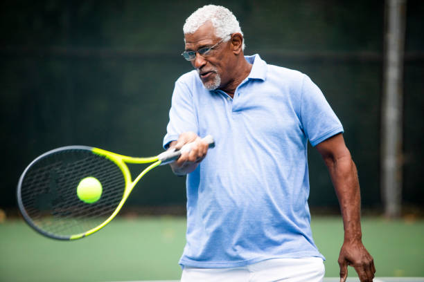 senior hombre negro jugando tenis - tennis senior adult adult mature adult fotografías e imágenes de stock