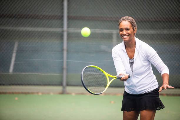 Beautiful Senior Black Woman Playing Tennis A beautiful senior black woman with her tennis racket playing tennis senior adult adult mature adult stock pictures, royalty-free photos & images