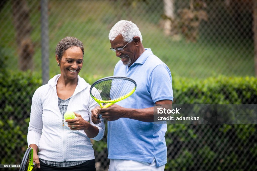 Senior Black Couple on Tennis Court A senior black couple together on the tennis court. Tennis Stock Photo