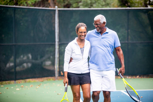 couple de personnes âgées noir sur un court de tennis - tennis senior adult adult mature adult photos et images de collection