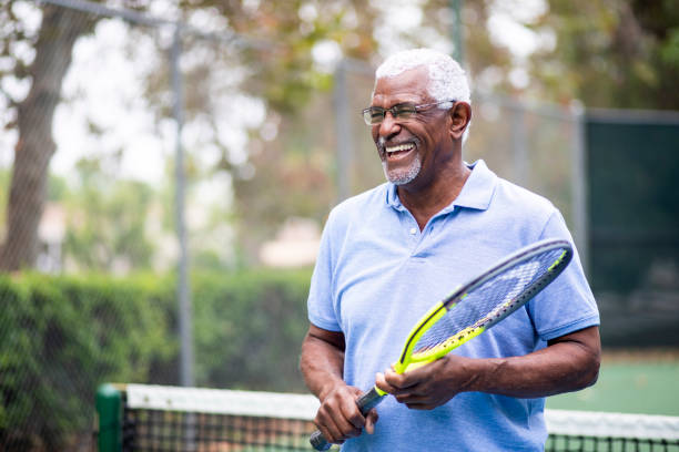 Senior Black Man Playing Tennis Portrait of a senior black man with a tennis racket one senior man only stock pictures, royalty-free photos & images