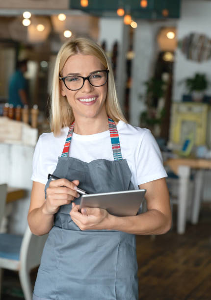 istock Happy waitress working at a restaurant and using a digital tablet 1058169068