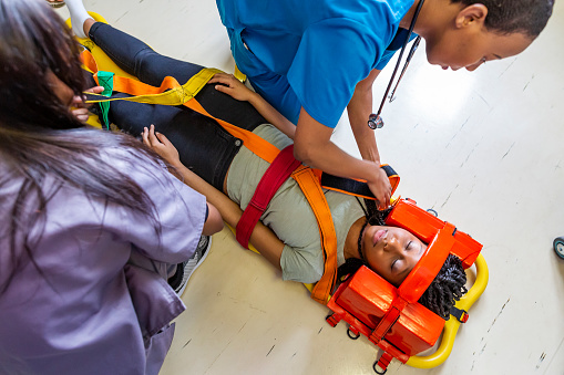 Patient with spinal injuries being examined by doctors while in a neck brace