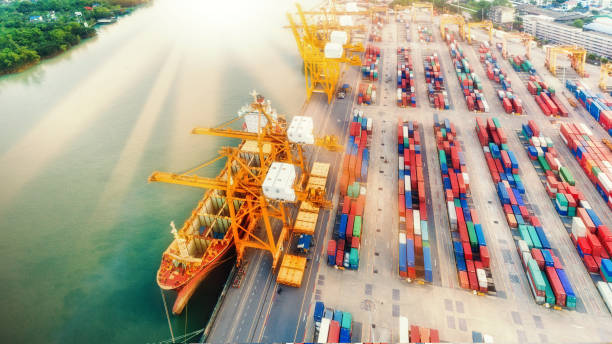 istock Aerial view container ship from sea port warehouse with working crane bridge unloading containers shipment. Suitable use for transport or import export to global logistics concept. 1058174192