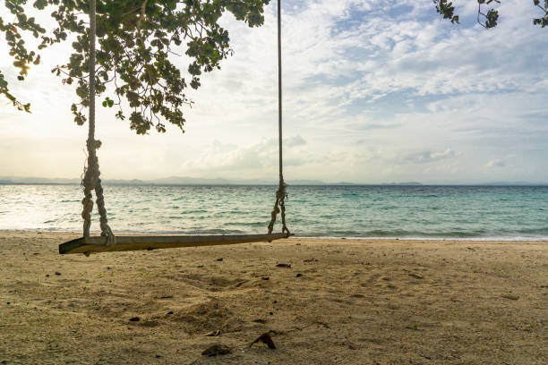 istock Empty swing seat on the beach in afternoon 1058177468