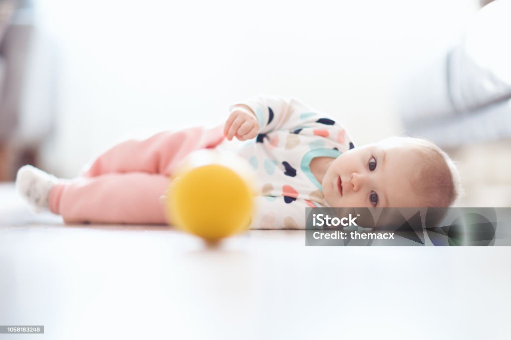 Bebê rolando rolando no chão - Foto de stock de 6-11 meses royalty-free