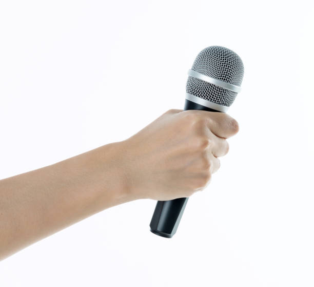 istock Woman hand holding a microphone on white background 1058186530