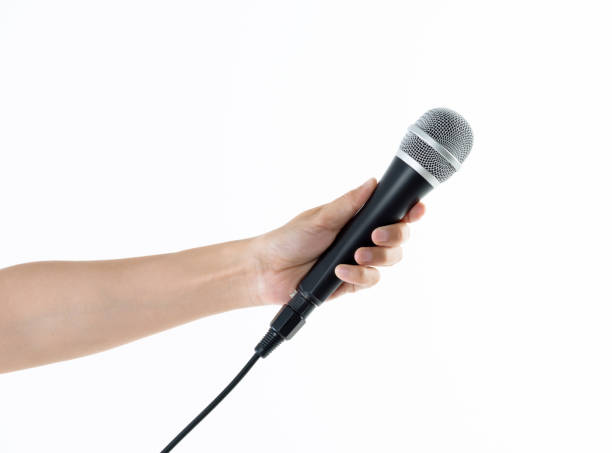 istock Woman hand holding a microphone on white background 1058186540