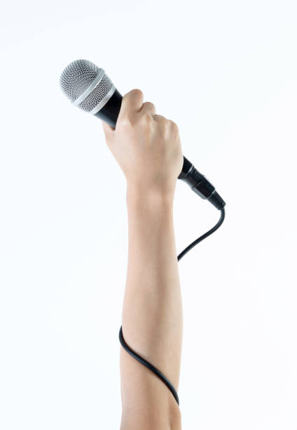 istock Woman hand holding a microphone on white background 1058186580