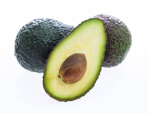 istock Whole avocados and one half avocado on white background 1058187922