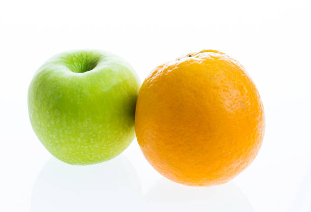 istock Green apple and orange on white background 1058188010