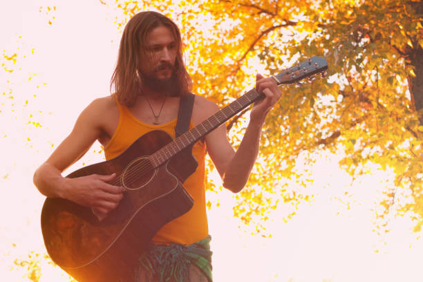 istock Hippie man playing acoustic guitar 1058188196