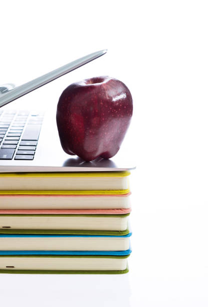 istock Apple with books and laptop on white background 1058192114