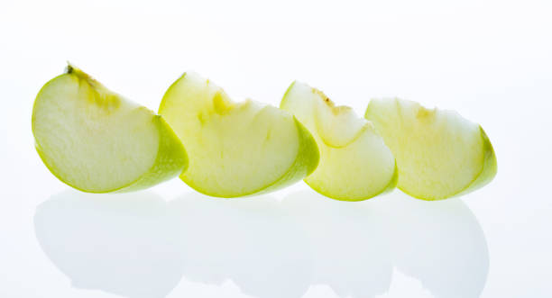 istock Green apple slices on white background 1058192340