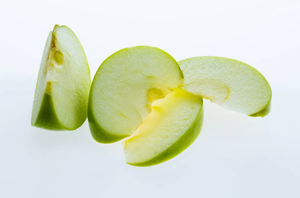 istock Green apple slices on white background 1058192400