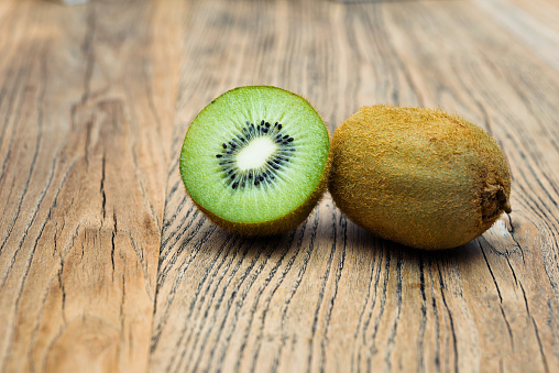Fresh kiwi fruits on wooden table.