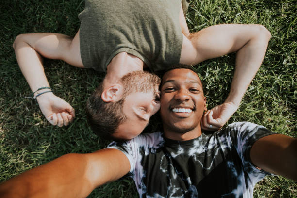 istock Gay couple relaxing in the grass 1058195936
