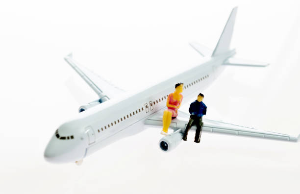 istock Two figurines sitting on airplane wing 1058199750