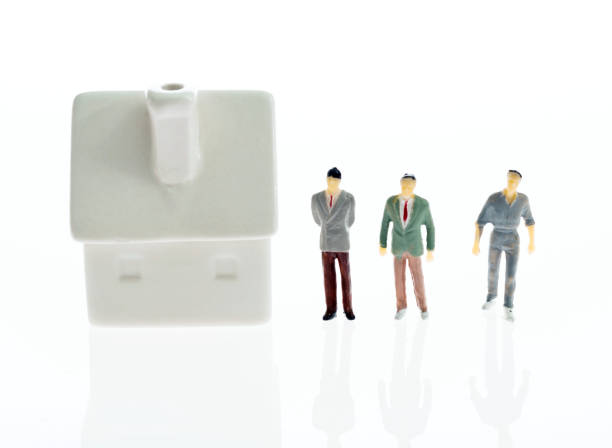 istock Male figurines standing outside the house 1058199756