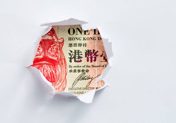 Hong Kong currency in the hole of paper Hong Kong currency in the hole of paper. bills lions stock pictures, royalty-free photos & images