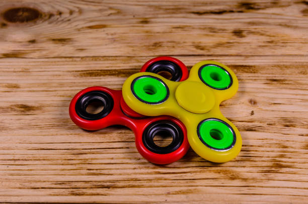 istock Two fidget spinners on wooden desk 1058201900