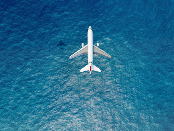 Airplane flies over a sea Airplane flies over a sea planes flying overhead stock pictures, royalty-free photos & images