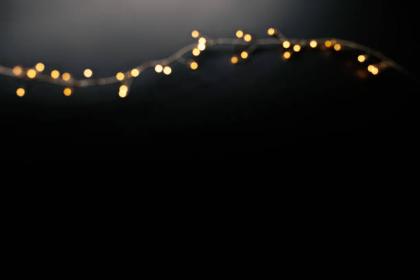 istock Abstract christmas lights on  black  background. Defocused  Glowing light bulb garland, copyspace 1058206682