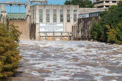 Austin Flooding - Tom Miller Dam Opens Flood Gates after Historic Flooding , water rushing out of dam , white wash and fast moving dirty brown water
