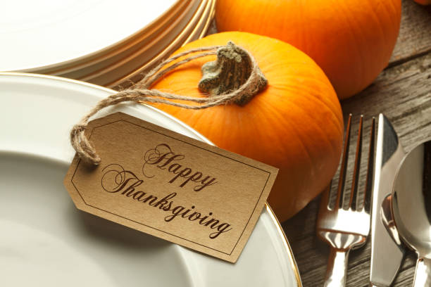 istock Happy Thanksgiving Tag Hangs From A Pumpkin And Rests On Stack Of Plates 1058214696