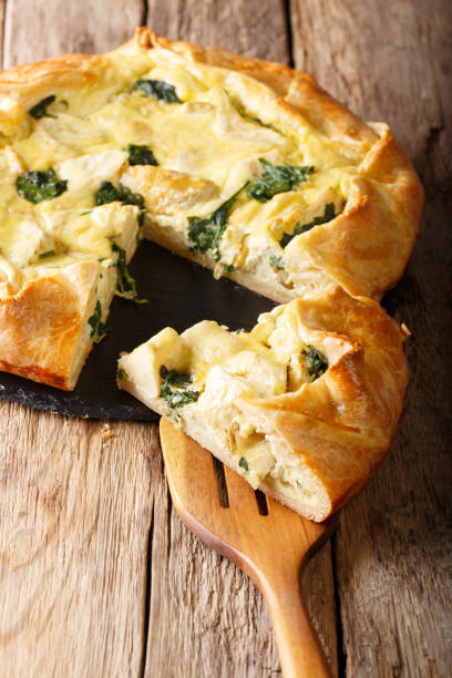 istock Snack crispy pie with artichokes, cheese and spinach close-up. vertical 1058218556