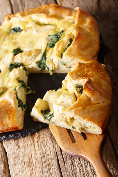 istock Homemade open savory pie with artichokes, cheese and spinach close-up. vertical 1058218676