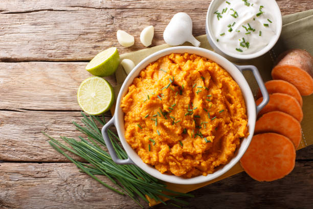 istock Freshly prepared mashed sweet potatoes with herbs, garlic and lime close up in a pot. horizontal top view 1058225290