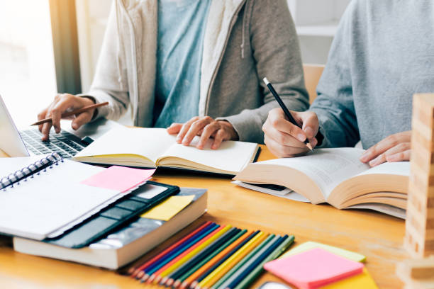 istock Teenager studying at desk and doing homeworks and using laptop. 1058225784