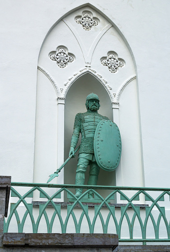 St. Petersburg, Russia, summer 2017: Pushkin city, Alexander Park, sculpture of a knight with a sword and shield in the niche of the facade of the White Tower complex