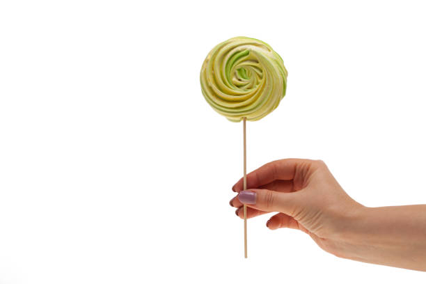 istock hand holding big colorful lollipop candy on stick, isolated on white 1058230726