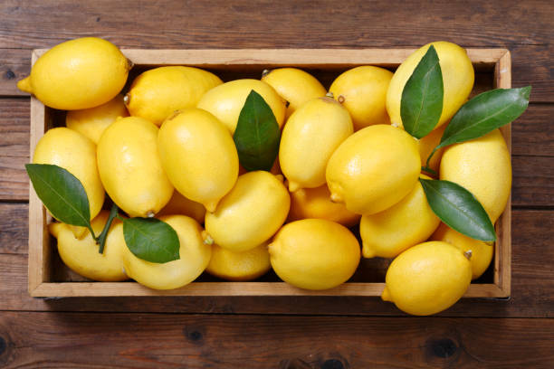istock fresh lemons in a wooden box, top view 1058241282