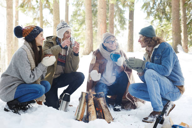 istock Young People Enjoying Drinks in Winter Forest 1058241770