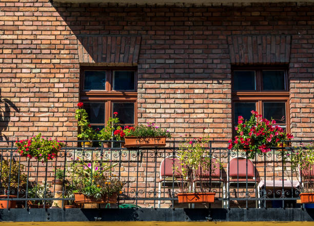 Red brick building with a beautiful floral balcony in the city.