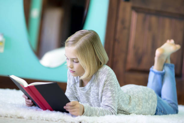 istock A blonde elementary age girl reads in her bedroom 1058250438