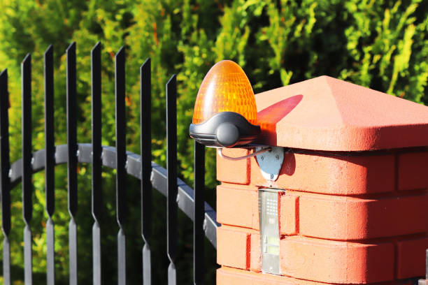 istock Orange room alarm light located on a brick fence post. Intercom apartment building at the entrance to a private protected area. Hazard alert. Intercom for door curtain. Property Protection and Securit 1058254120