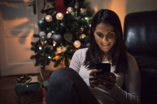 istock Young woman using a mobile phone at Christmas night 1058258114