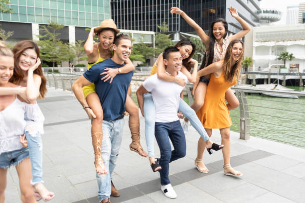 istock Couples having fun in piggyback ride on street 1058258654