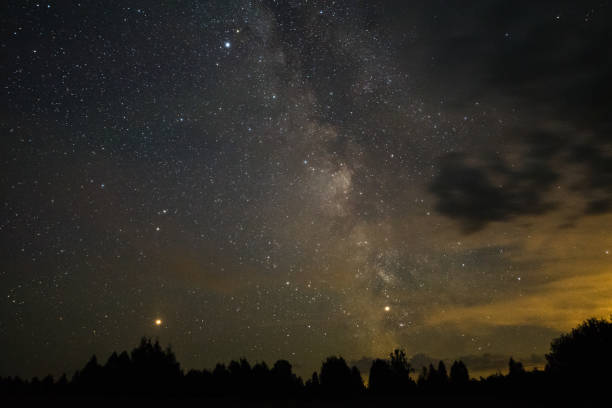 istock Bright milky way on a summer night through the clouds 1058265452