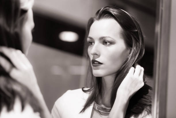 Beautiful young sexy woman looking in the mirror.